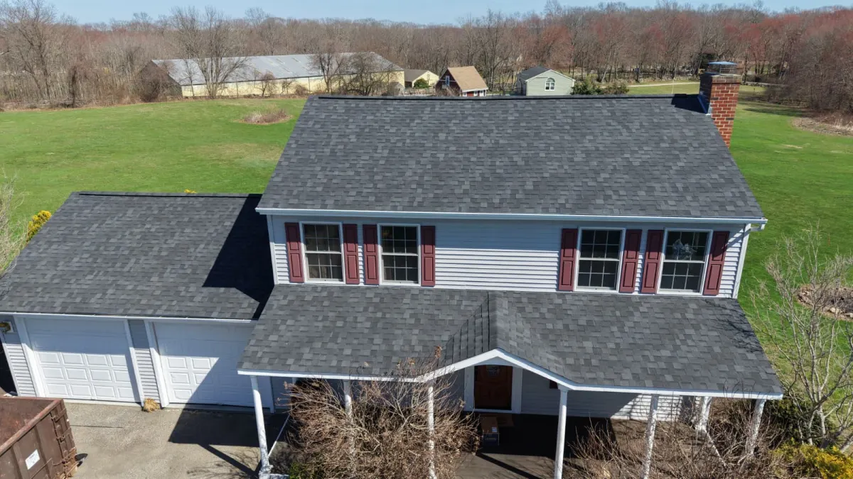 Colonial home with new roof and red shutters
