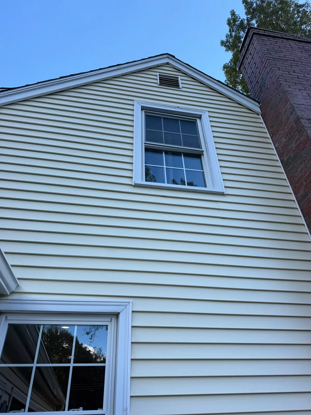 Cream vinyl siding gable end with double-hung window