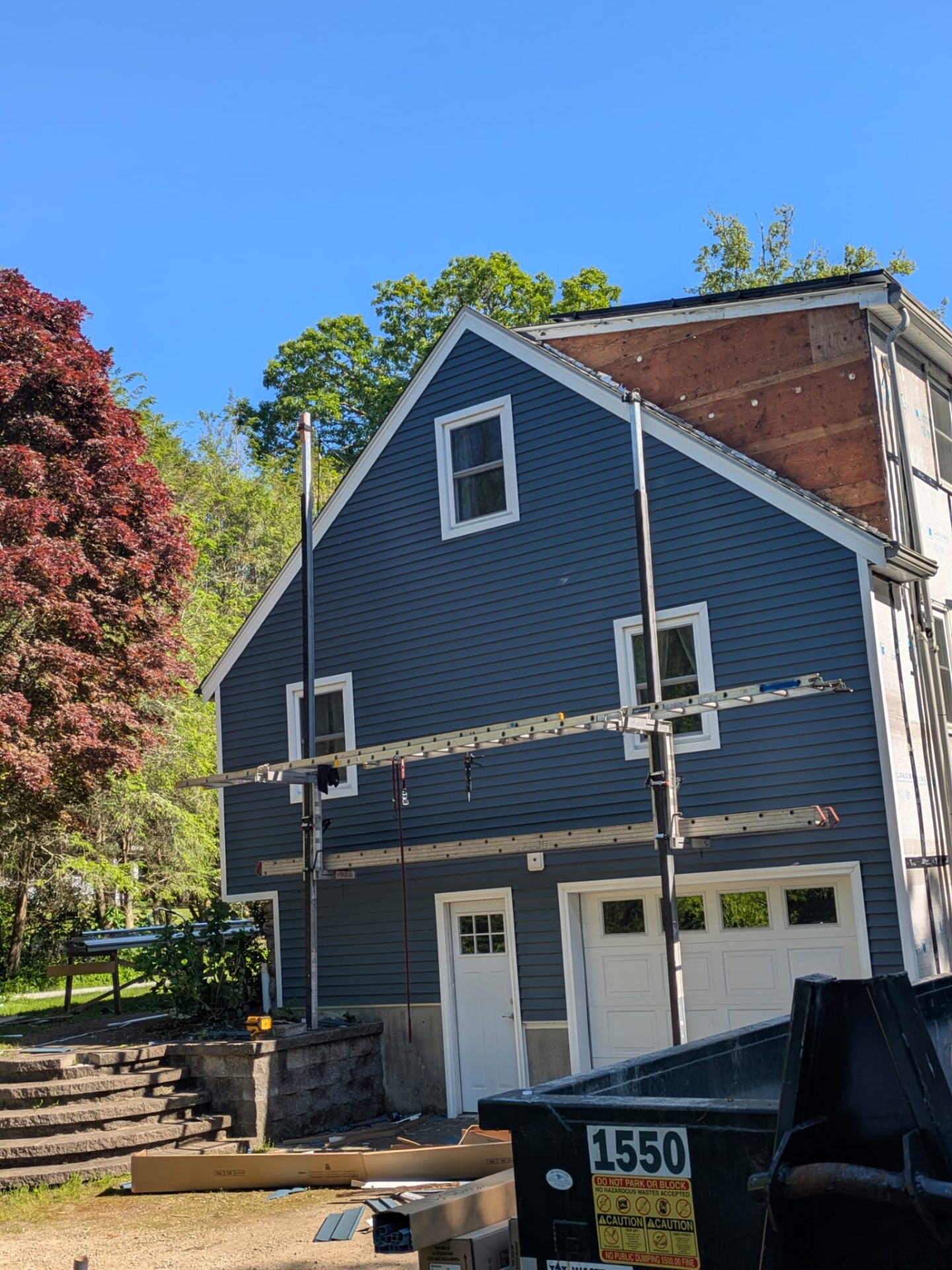 Home with dark blue siding and installation scaffolding
