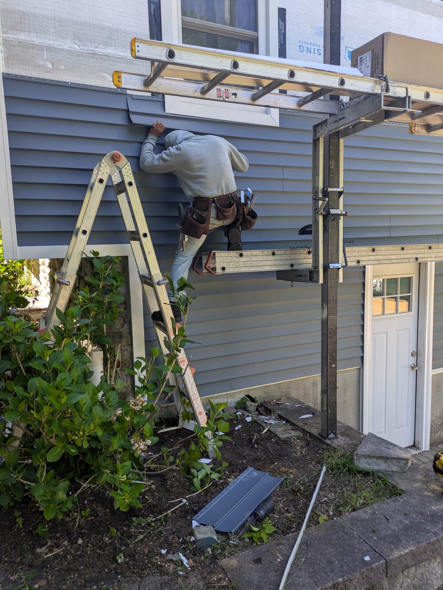 Worker installing vinyl siding